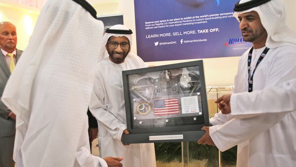 Khalifa Mohammed Al Rumaithi, Chairman of the UAE Space Agency, center, receives a United States of America flag and other memorabilia from the 1971 Apollo 14 lunar mission from Kallman Worldwide during the third day of the Dubai Airshow in the United Arab Emirates, Tuesday, Nov. 10, 2015. - Sputnik International