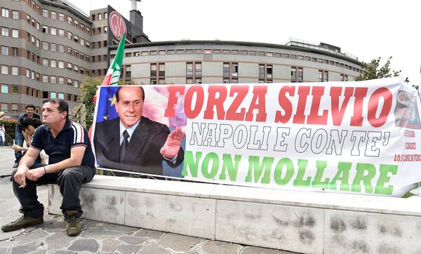 A man sits next to a banner reading Come on Silvio, Naples is with you, never give up in front of San Raffaele hospital, as Italian surgeons begin a four-hour heart operation on former prime minister Silvio Berlusconi on Tuesday to replace a defective aortic valve, a hospital statement said, in Milan, Italy June 14, 2016.  - Sputnik International