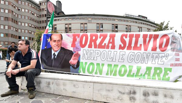 A man sits next to a banner reading Come on Silvio, Naples is with you, never give up in front of San Raffaele hospital, as Italian surgeons begin a four-hour heart operation on former prime minister Silvio Berlusconi on Tuesday to replace a defective aortic valve, a hospital statement said, in Milan, Italy June 14, 2016. - Sputnik International