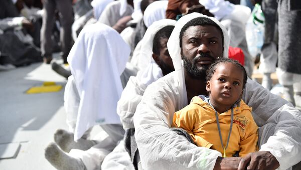 A man and his daughter wait during a distribution of meals aboard the rescue ship Aquarius, on May 25, 2016 a day after a rescue operation of migrants and refugees off the Libyan coast. - Sputnik International