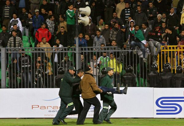 Egyptian medics carry a fan wounded during clashes between rival football fans after a football match between Al-Masry and Al-Ahly in Port Said on February 1, 2012. (File) Egyptian medics carry a fan wounded during clashes between rival football fans after a football match between Al-Masry and Al-Ahly in Port Said on February 1, 2012. (File) - Sputnik International