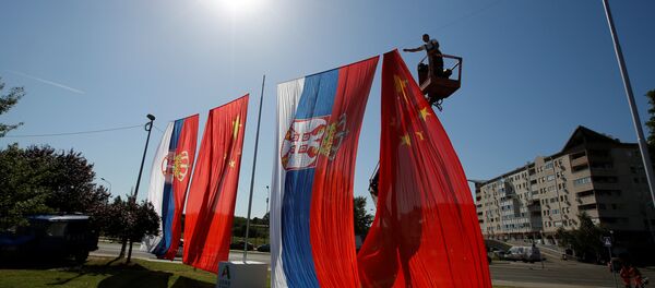A worker adjusts Chinese and Serbian flags for the upcoming visit of Chinese President Xi Jinping A worker adjusts Chinese and Serbian flags for the upcoming visit of Chinese President Xi Jinping - Sputnik International