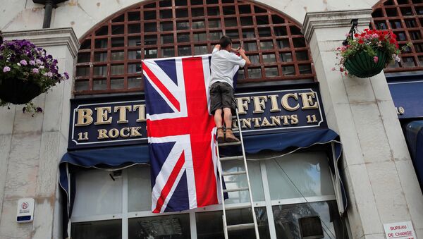 A worker places the Union Jack flag on the facade of a shop at Casesmates square where British Prime Minister David Cameron will attend a 'Stronger In' campaign event in the British overseas territory Gibraltar, historically claimed by Spain, June 16, 2016. - Sputnik International