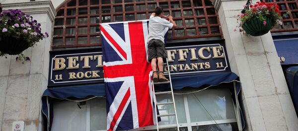 A worker places the Union Jack flag on the facade of a shop at Casesmates square where British Prime Minister David Cameron will attend a 'Stronger In' campaign event in the British overseas territory Gibraltar, historically claimed by Spain, June 16, 2016. - Sputnik International