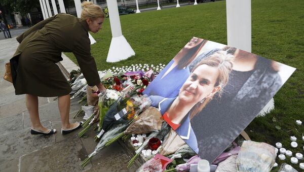A woman leaves a floral tribute next to a photograph of murdered Labour Member of Parliament Jo Cox in Parliament Square, London, Britain June 17, 2016 - Sputnik International
