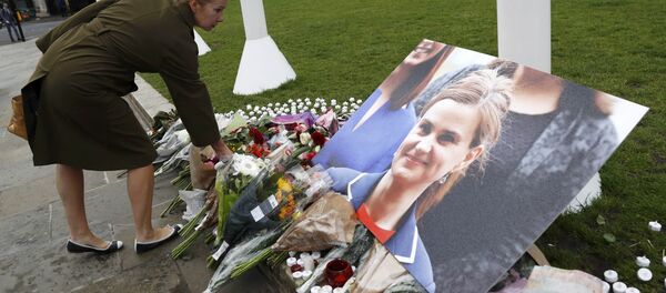 A woman leaves a floral tribute next to a photograph of murdered Labour Member of Parliament Jo Cox in Parliament Square, London, Britain June 17, 2016 - Sputnik International