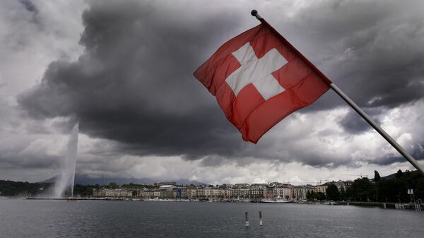 A Swiss flag flies on the shores of Geneva Lake in front of the Geneva Fountain (L) on June 14, 2013 in the center of Geneva - Sputnik International