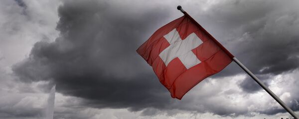 A Swiss flag flies on the shores of Geneva Lake in front of the Geneva Fountain (L) on June 14, 2013 in the center of Geneva - Sputnik International