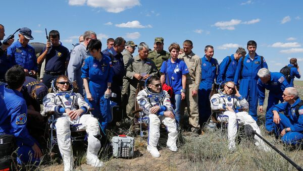 The International Space Station (ISS) crew members Timothy Peake of Britain, Yuri Malenchenko of Russia and Timothy Kopra of the U.S., surrounded by ground personnel, rest shortly after landing near the town of Dzhezkazgan (Zhezkazgan), Kazakhstan, June 18, 2016 - Sputnik International