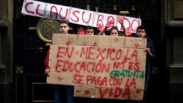Activists hold signs during a demonstration at the door of the Secretary of Education building, following clashes in southern Mexico over the weekend between police and members of the National Coordination of Education Workers (CNTE) in Mexico City, Mexico, June 21, 2016 - Sputnik International
