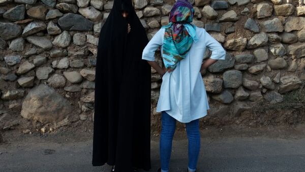 Today in the streets of Tehran and other large Iranian cities (Isfaghan, Shiraz, Tebriz) often women are seen wearing two types of hijabs: Chador (left) and Manto (loose colorful body cover) with Rosari (light headscarf with colorful flowers). First option is more conservative, second is modern and popular with the younger generation. - Sputnik International
