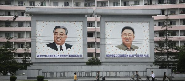 North Koreans are dwarfed against giant portraits of the late North Korean leaders Kim Il Sung and Kim Jong Il as they walk past an apartment building on Wednesday, June 22, 2016, in Wonsan, North Korea. North Koreans are dwarfed against giant portraits of the late North Korean leaders Kim Il Sung and Kim Jong Il as they walk past an apartment building on Wednesday, June 22, 2016, in Wonsan, North Korea. - Sputnik International