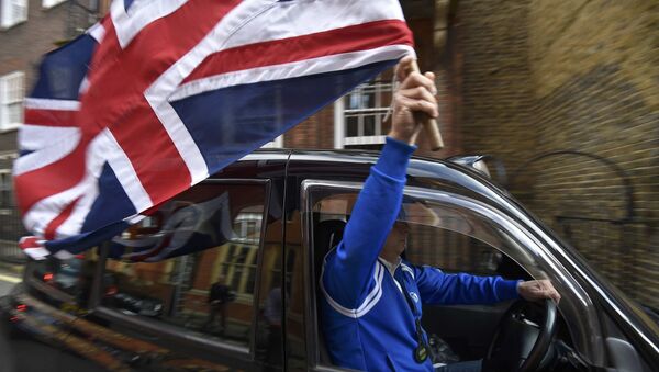 A taxi driver holds a Union flag, as he celebrates following the result of the EU referendum, in central London, Britain June 24, 2016. - Sputnik International