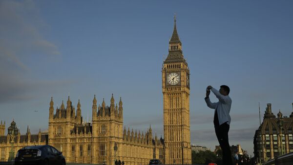A man takes a photo as he stands on Westminster bridge with the Houses of Parliament in the background in London, Friday, June 24, 2016. - Sputnik International