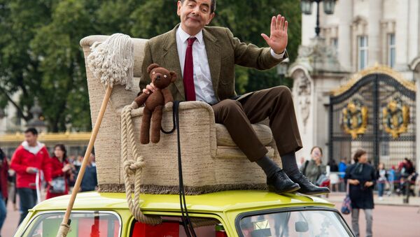 British actor Rowan Atkinson, dressed as Mr Bean, sits on top of a Mini Cooper outside Buckingham Palace, London, to promote the 25th anniversary of Mr Bean, London, Friday, Sept. 4, 2015. - Sputnik International