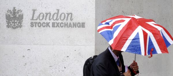 A worker shelters from the rain as he passes the London Stock Exchange in the City of London at lunchtime - Sputnik International