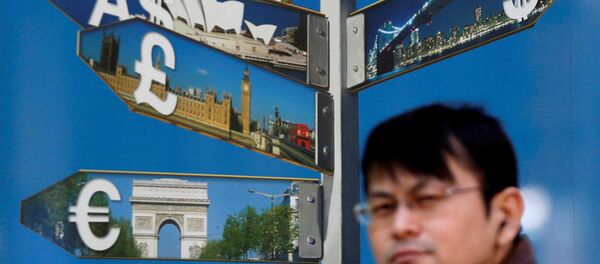 A man walks past various currency signs, including the dollar (top R), Australian dollar (top L), pound sterling (centre L) and Euro (bottom L), outside a brokerage in Tokyo October 28, 2014 - Sputnik International