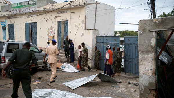 Somali government soldiers and police gather near the scene of gunfire after a suicide bomb attack outside Nasahablood hotel in Somalia's capital Mogadishu, June 25, 2016 - Sputnik International