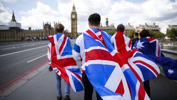People walk over Westminster Bridge wrapped in Union flags, towards the Queen Elizabeth Tower (Big Ben) and The Houses of Parliament in central London on June 26, 2016 - Sputnik International