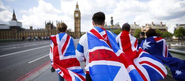 People walk over Westminster Bridge wrapped in Union flags, towards the Queen Elizabeth Tower (Big Ben) and The Houses of Parliament in central London on June 26, 2016 - Sputnik International