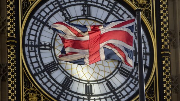 The Union flag is seen flapping in the wind in front of one of the faces of the Great Clock atop the landmark Elizabeth Tower that houses Big Ben at the Houses of Parliament where lawmakers are expected to vote in favour of joining air strikes against Islamic State (IS) militants in central London on 26 September, 2014 - Sputnik International