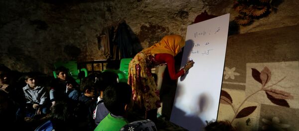 A teacher conducts a lesson for internally displaced children inside a cave in the rebel-controlled village of Tramla, in Idlib province, Syria March 27, 2016 - Sputnik International