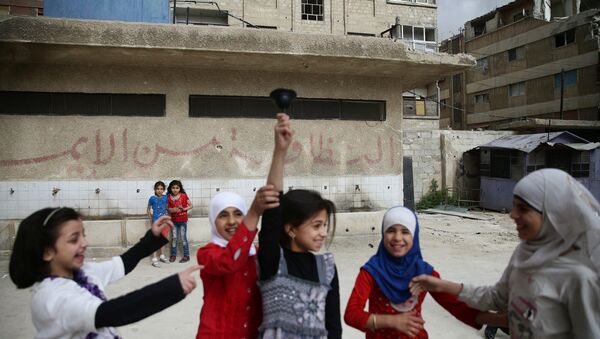 Girls ring a bell inside a school yard in the town of Douma, eastern Ghouta in Damascus, Syria May 24, 2016 - Sputnik International