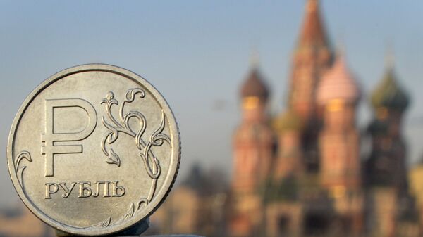 A Russian ruble coin is pictured in front of St. Basil cathedral in central Moscow - Sputnik International