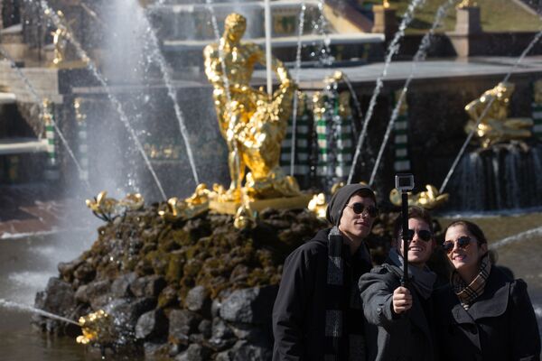 Young people pose for photographs by a Grand Cascade fountain on the opening day of fountains season at the Peterhof State Museum Reserve Young people pose for photographs by a Grand Cascade fountain on the opening day of fountains season at the Peterhof State Museum Reserve - Sputnik International