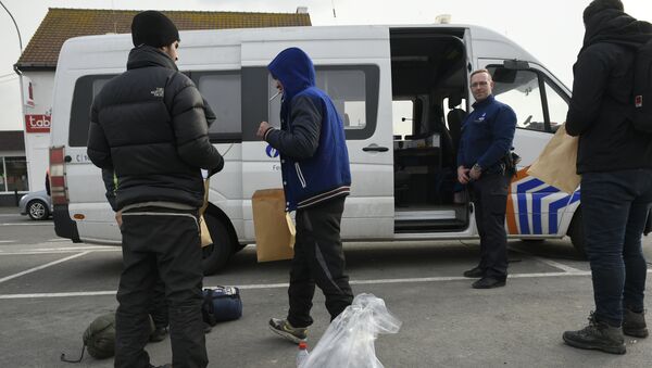 Migrants, who were arrested earlier in Belgium, are released by Belgian police officers near the Belgian-French border on February 26, 2016 in Adinkerke. - Sputnik International