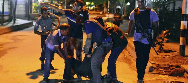 People help an unidentified injured person after a group of gunmen attacked a restaurant popular with foreigners in a diplomatic zone of the Bangladeshi capital Dhaka, Bangladesh, Friday, July 1, 2016. People help an unidentified injured person after a group of gunmen attacked a restaurant popular with foreigners in a diplomatic zone of the Bangladeshi capital Dhaka, Bangladesh, Friday, July 1, 2016. - Sputnik International