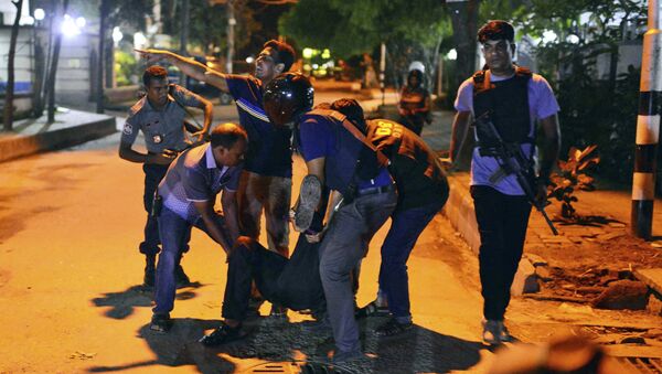 People help an unidentified injured person after a group of gunmen attacked a restaurant popular with foreigners in a diplomatic zone of the Bangladeshi capital Dhaka, Bangladesh, Friday, July 1, 2016. - Sputnik International