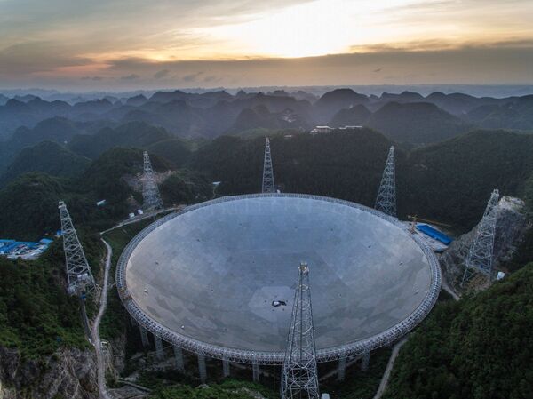 In this photo released by China's Xinhua News Agency, the sun sets above the Five-hundred-meter Aperture Spherical Telescope (FAST) in Pingtang County in southwestern China's Guizhou Province Monday, June 27, 2016 In this photo released by China's Xinhua News Agency, the sun sets above the Five-hundred-meter Aperture Spherical Telescope (FAST) in Pingtang County in southwestern China's Guizhou Province Monday, June 27, 2016 - Sputnik International