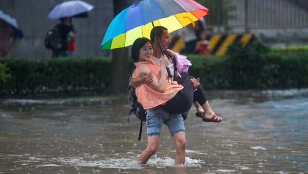 This picture taken on July 2, 2016 shows people crossing a flooded street in Wuhan, in China's central Hubei province - Sputnik International