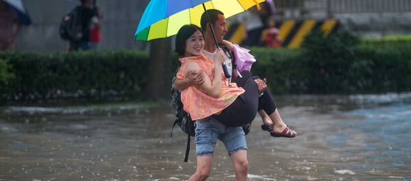 This picture taken on July 2, 2016 shows people crossing a flooded street in Wuhan, in China's central Hubei province - Sputnik International