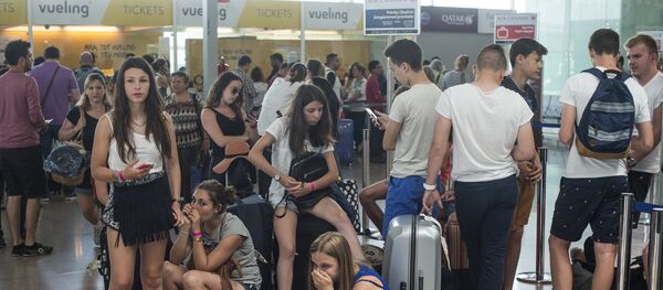 Passengers queue in front of Spanish low-cost airline Vueling check-in counters at the El Prat Airport in Barcelona on July 5, 2016 - Sputnik International