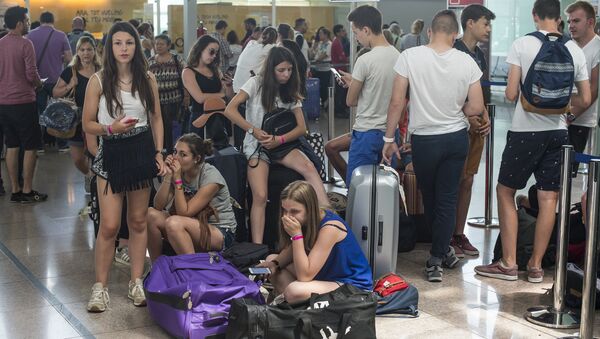 Passengers queue in front of Spanish low-cost airline Vueling check-in counters at the El Prat Airport in Barcelona on July 5, 2016 - Sputnik International