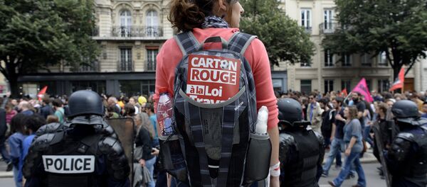 A woman carrying a backpack with a sticker reading Red card to the labour law stands behind French CRS anti-riot police during a demonstration against the government's proposed labour reforms in Paris on July 5, 2016 - Sputnik International