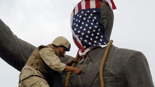 A US Marine covers the head of a statue of Iraqi President Saddam Hussein with the US flag before pulling it down in Baghdad's al-Fardous (paradise) Square on 9 April 2003 as the marines swept into the Iraqi capital and the Iraqi leader's regime collapsed. - Sputnik International