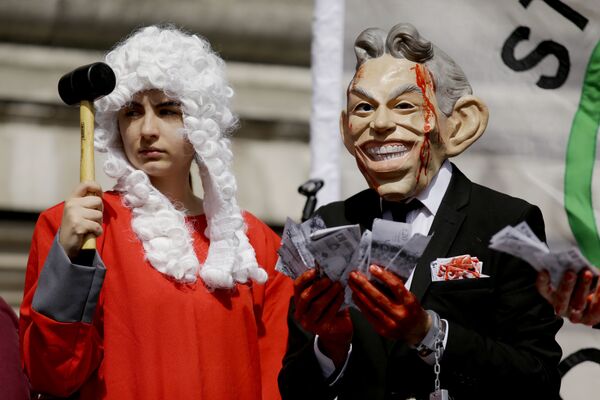 A protester wearing a former British Prime Minister Tony Blair mask, right, and another dressed as a judge pose for the media on a stage outside the Queen Elizabeth II Conference Centre in London, shortly before the publication of the Chilcot report into the Iraq war, Wednesday, July 6, 2016. A protester wearing a former British Prime Minister Tony Blair mask, right, and another dressed as a judge pose for the media on a stage outside the Queen Elizabeth II Conference Centre in London, shortly before the publication of the Chilcot report into the Iraq war, Wednesday, July 6, 2016. - Sputnik International