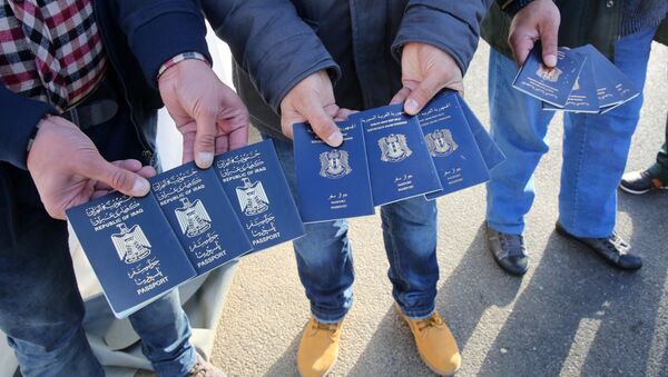 Migrants show passports from Iraqi and Syrian fellow travellers they have to present to buy ferry tickets for their passage to Sweden (photo used for illustration purpose) - Sputnik International
