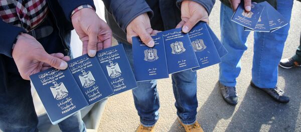 Migrants show passports from Iraqi and Syrian fellow travellers they have to present to buy ferry tickets for their passage to Sweden Migrants show passports from Iraqi and Syrian fellow travellers they have to present to buy ferry tickets for their passage to Sweden - Sputnik International
