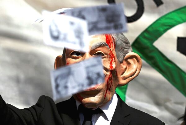 A demonstrator wearing a mask to impersonate Tony Blair holds throws fake money during a protest before the release of the John Chilcot report into the Iraq war, at the Queen Elizabeth II center in London, Britain July 6, 2016. A demonstrator wearing a mask to impersonate Tony Blair holds throws fake money during a protest before the release of the John Chilcot report into the Iraq war, at the Queen Elizabeth II center in London, Britain July 6, 2016. - Sputnik International