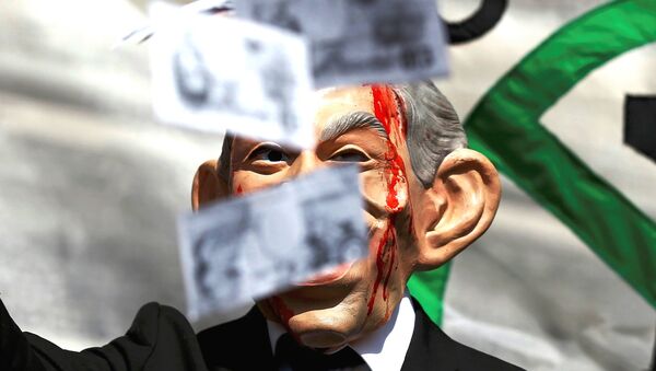 A demonstrator wearing a mask to impersonate Tony Blair holds throws fake money during a protest before the release of the John Chilcot report into the Iraq war, at the Queen Elizabeth II center in London, Britain July 6, 2016. - Sputnik International