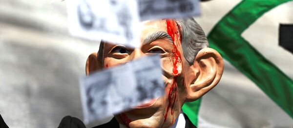 A demonstrator wearing a mask to impersonate Tony Blair holds throws fake money during a protest before the release of the John Chilcot report into the Iraq war, at the Queen Elizabeth II center in London, Britain July 6, 2016. - Sputnik International