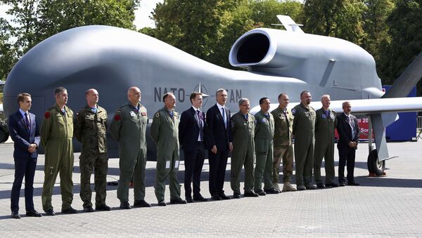 NATO Secretary-General Jens Stoltenberg (C) poses with officials and military personnel in front of a NATO unmanned drone outside PGE National Stadium, the venue of the NATO Summit, in Warsaw, Poland, July 8, 2016. - Sputnik International