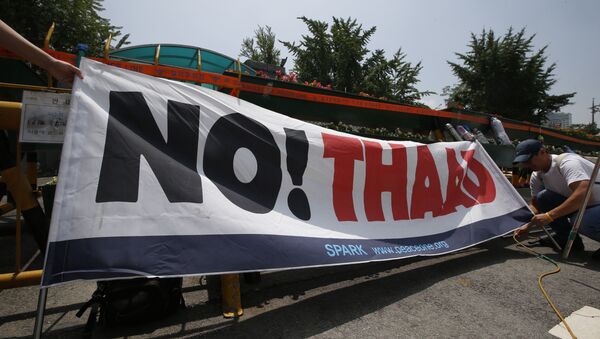A South Korean protester ties a banner before a rally to denounce deploying the Terminal High-Altitude Area Defense, or THAAD, in front of the Defense Ministry in Seoul, South Korea, Friday, July 8, 2016. - Sputnik International