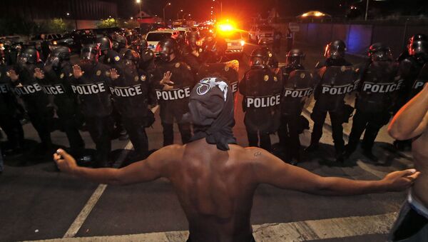 A protester raises him arms in front of a police blockade as marchers take to the streets to demonstrate against the recent fatal shootings of black men by police, Friday, July 8, 2016, in Phoenix. - Sputnik International