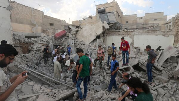 Men look for survivors under the rubble of a damaged building after an airstrike on Aleppo's rebel held Kadi Askar area, Syria July 8, 2016. - Sputnik International