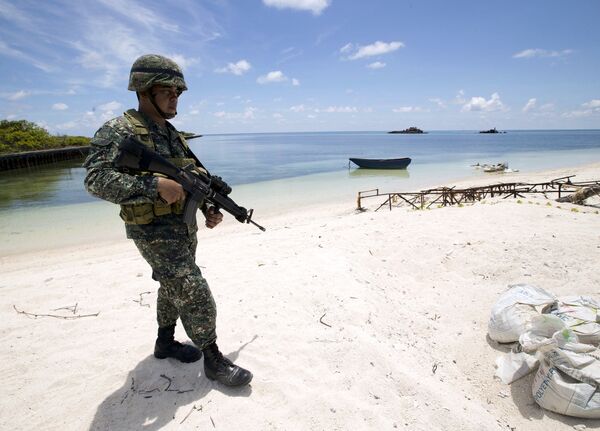 A Filipino soldier patrols at the shore of Pagasa island (Thitu Island) in the Spratly group of islands in the South China Sea, west of Palawan, Philippines, May 11, 2015. A Filipino soldier patrols at the shore of Pagasa island (Thitu Island) in the Spratly group of islands in the South China Sea, west of Palawan, Philippines, May 11, 2015. - Sputnik International